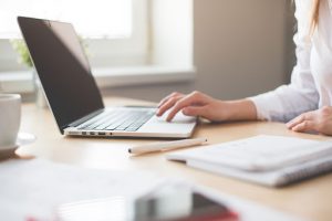 Mulher pesquisando em notebook como pesquisar no Diário Oficial da União