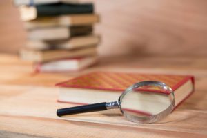 Lupa sobre livros, simbolizando a investigação feita por uma CPI.