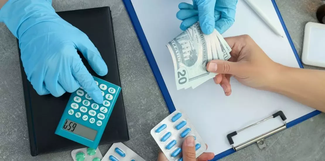 Pessoa comprando remédio e entregando dinheiro ao atendente de luva azul ilustrando a imunidade tributária.