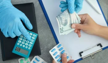 Pessoa comprando remédio e entregando dinheiro ao atendente de luva azul ilustrando a imunidade tributária.