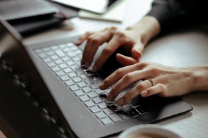 Foto de mãos digitando em teclado, representando uma consulta de CNPJ