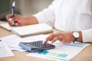 Pessoa calculando quais são os tipos de tributos e como reduzir as contas.